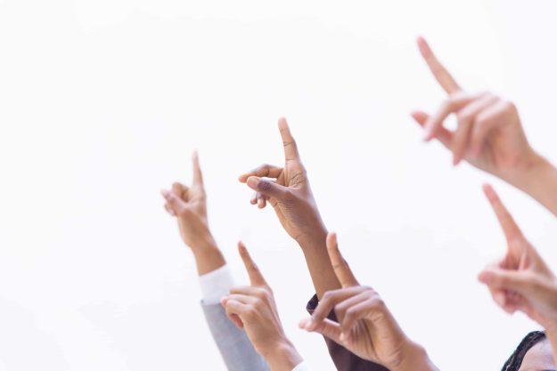 Hands of businesspeople pointing index fingers up